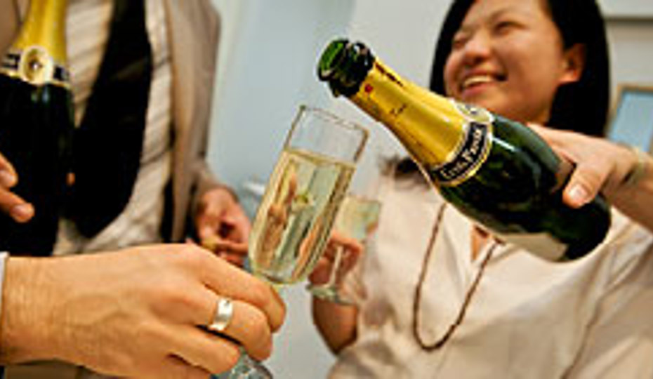 Smiling person with a glass of champagne being poured in the foreground