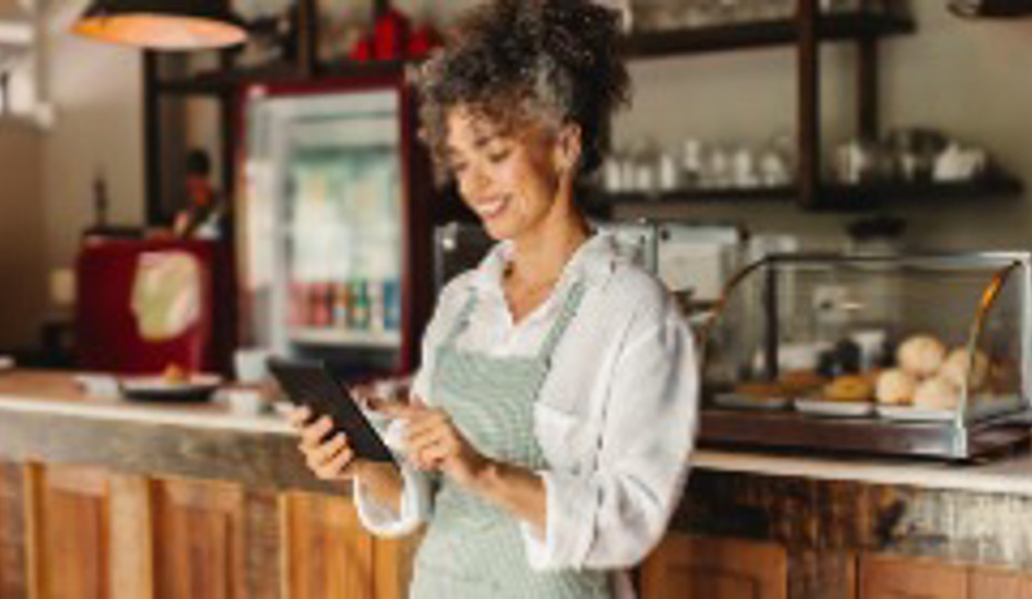 Business owner using a digital tablet in her cafe